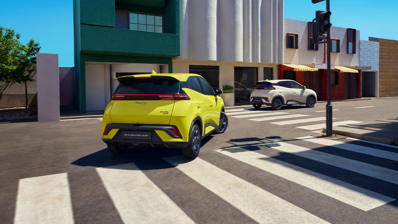 Gelber BYD Dolphin Surf Elektro-SUV beim Abbiegen an einer Kreuzung in urbaner Umgebung
